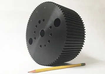 Dark geared drum machined from solid, with a pencil for scale
